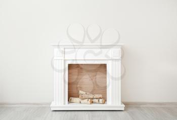 Modern fireplace near wall in room�
