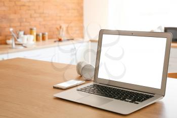 Modern laptop at workplace in kitchen�