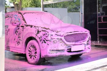 Modern automobile in foam at car wash�