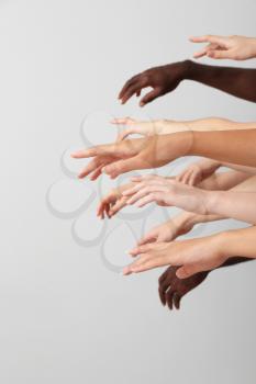 Hands of Caucasian women and African-American man on grey background. Racism concept�