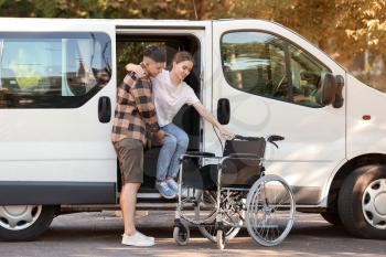 Man helping his handicapped wife to get out of van�