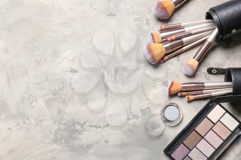 Set of makeup brushes and cosmetics on light background�