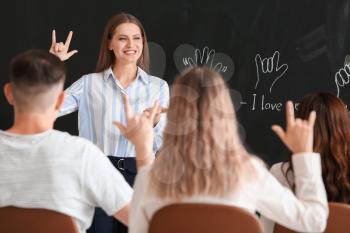 Teacher conducting courses for deaf mute people in classroom�