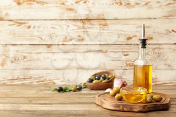 Composition with olive oil on wooden table�