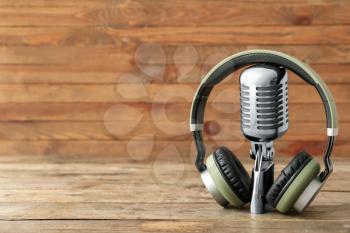 Headphones with microphone on wooden background�