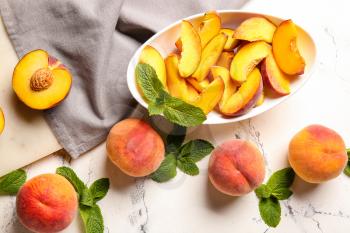 Composition with whole and cut ripe peaches on table�