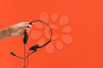 Female hand with headset on color background�