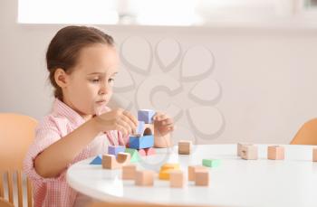 Little girl with autistic disorder playing with blocks at home�