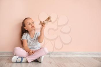 Little girl with autistic disorder playing with toy near color wall�