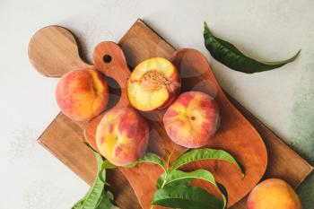 Boards with ripe peaches on light background�