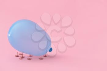 Balloon and pushpins on color background�