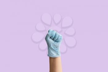 Gesturing hand in protective glove on color background�
