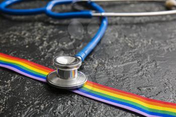 Stethoscope and rainbow ribbon of LGBT on dark background�