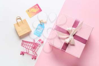 Shopping cart with credit card, bag, gift box and tag with text CYBER MONDAY SALE on color background�