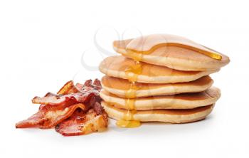 Tasty pancakes with fried bacon on white background�