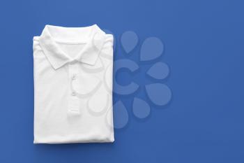 Folded polo shirt on color background�
