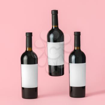Bottles of wine with blank labels on color background. Mockup for design�