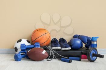 Set of sport equipment on floor near color wall�