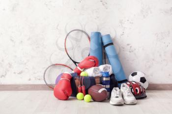 Set of sports equipment on floor near light wall�