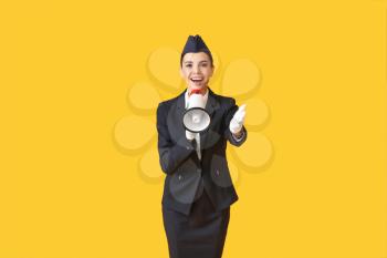 Beautiful stewardess with megaphone on color background�