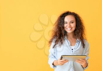 Young woman with tablet computer on color background�
