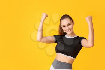 Happy sporty young woman on color background. Concept of goal achievement�