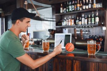 Young man placing sports bet in pub�