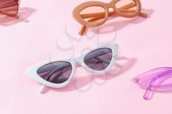 Stylish sunglasses on color background�