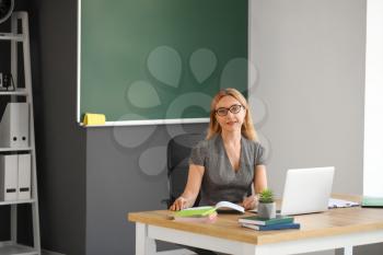 Mature female teacher working in classroom�