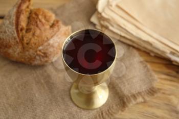 Chalice of wine with bread on table�