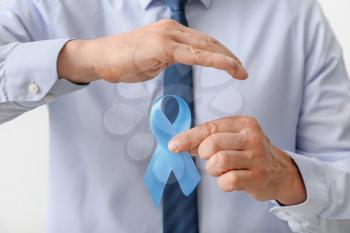 Man with blue ribbon, closeup. Prostate cancer awareness concept�