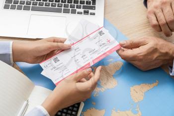 Travel agent giving client  tickets for future trip in office�