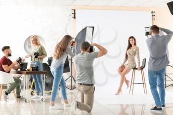 Young photographers taking picture of woman in studio�