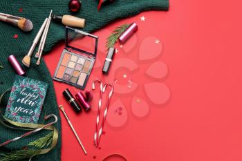 New Year composition with makeup cosmetics and clothes on color background�