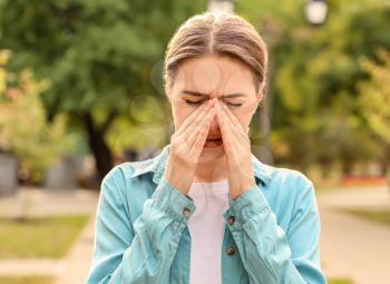 Young woman suffering from allergy outdoors�
