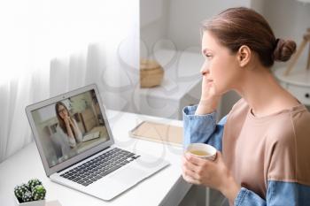Stressed young woman asking psychologist for advice online at home�