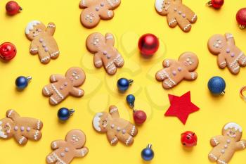 Tasty gingerbread cookies and Christmas decor on color background�