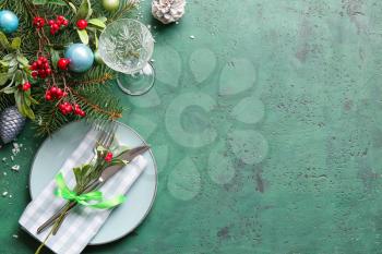 Beautiful Christmas table setting with mistletoe on color background�