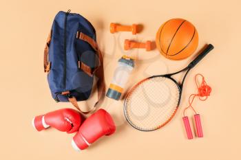 Composition with bag and sports equipment on color background�
