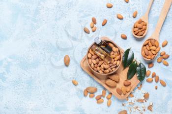Composition with almond oil and nuts on color background�