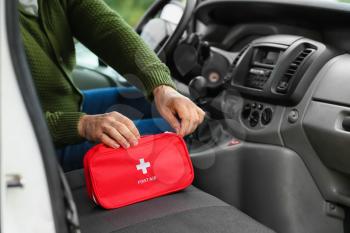 Man with first aid kit in car�