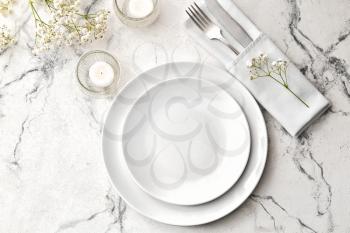 Beautiful table setting with burning candles and floral decor on light background�