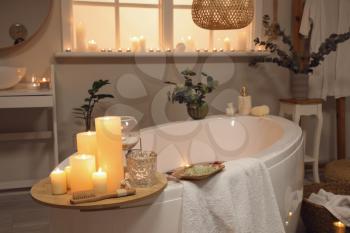 Interior of modern bathroom with burning candles in evening�