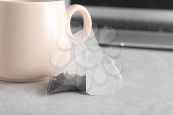 Bag with aromatic black tea on light background�