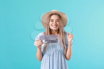 Beautiful young woman with gift voucher on color background�