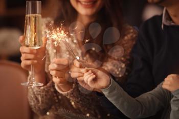 Happy family with sparklers and champagne celebrating Christmas at home�