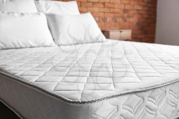 Bed with comfortable orthopedic mattress in room�