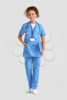 Female African-American doctor on light background�