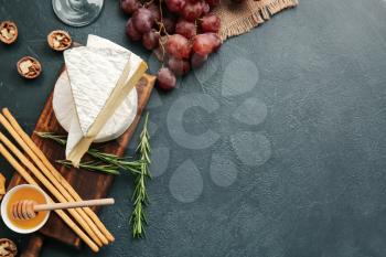 Composition with tasty cheese on dark background�