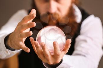 Male fortune teller with crystal ball reading future, closeup�